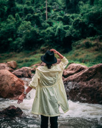 Rear view of woman standing on rock