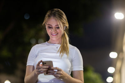 Young woman using mobile phone at night