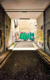 Covered walkway leading towards graffiti wall