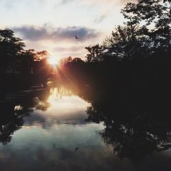 Scenic view of river against sky at sunset
