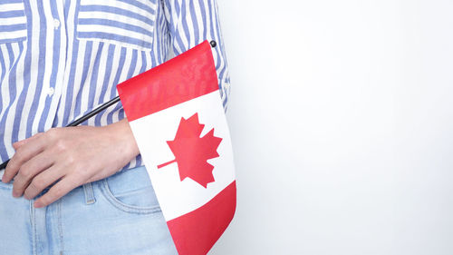 Midsection of woman holding american flag against white background