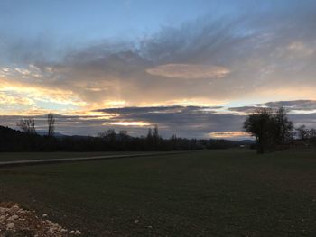 Scenic view of field against sky at sunset