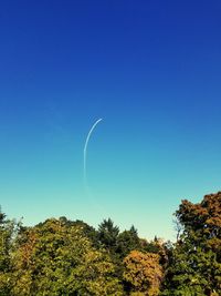 Low angle view of vapor trail against clear blue sky