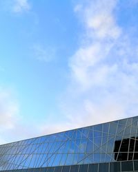 Low angle view of electricity pylon against blue sky