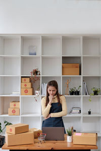 Side view of young woman sitting at home