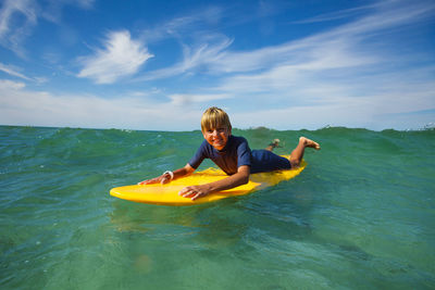 Rear view of woman swimming in sea against sky