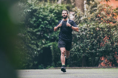 Determined man running outside in the park. fit boy doing exercise outdoor .beautiful sporty male