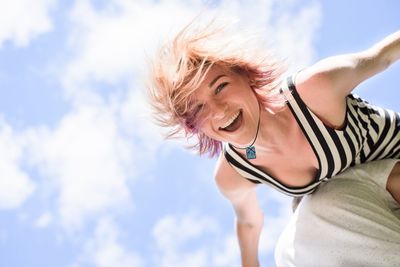 Low angle view of man carrying woman against sky