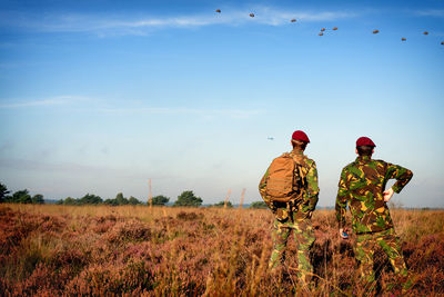 Rear view of soldiers standing on field