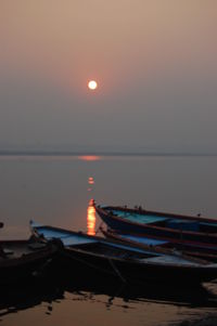 Boat moored on sea against sky at night