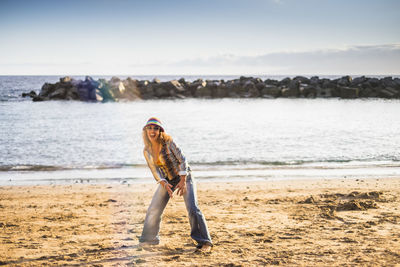 Portrait of happy woman standing at beach