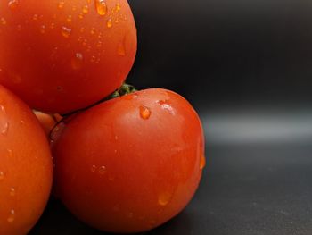 Close-up of wet orange fruit against black background