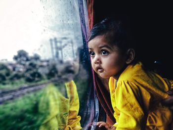 Girl looking away through train window