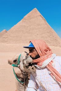 Man wearing sunglasses on desert against clear sky