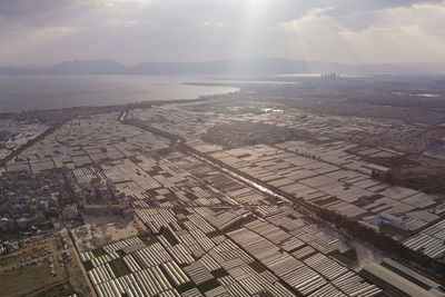 High angle view of city by sea against sky