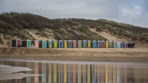 Multi colored chairs on beach against sky