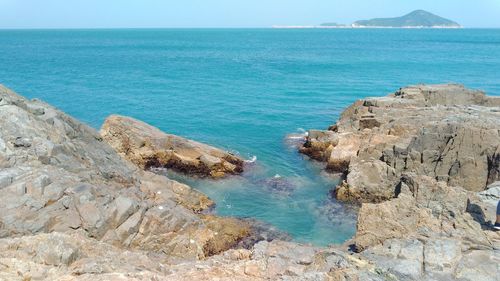 Scenic view of rocks in sea against sky