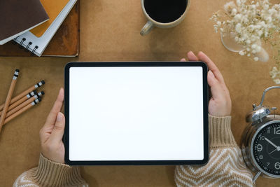 Cropped hands of woman using laptop on table