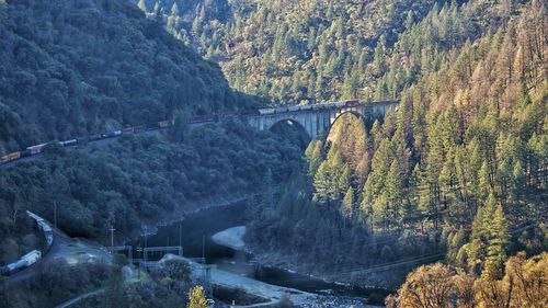 Arch bridge over river against mountains