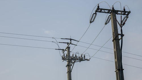Low angle view of electricity pylon against sky