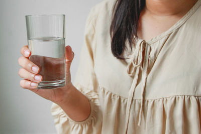 Midsection of woman drinking glass