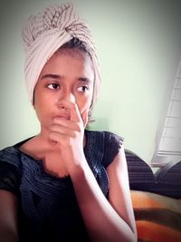 Portrait of boy looking away against wall at home