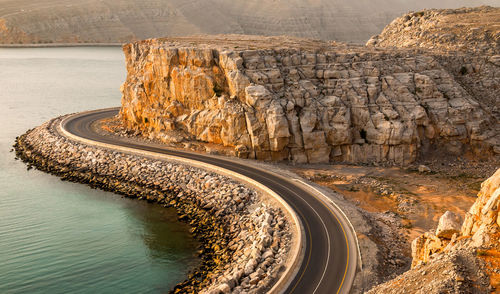 Road by cliff against sky