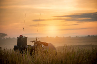 Scenic view of agricultural field against sky during sunset