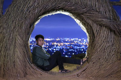 Side view portrait of young man sitting outdoors