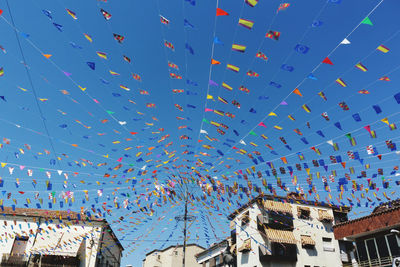 Low angle view of multi colored buildings against clear blue sky