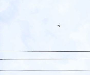 Low angle view of airplane flying against clear sky