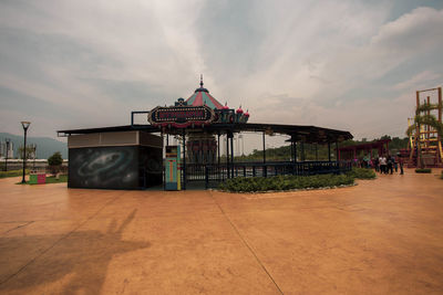 View of amusement park by building against sky