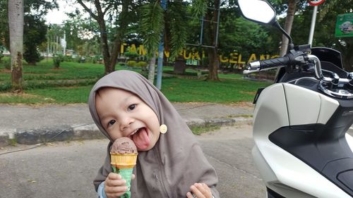 Portrait of boy with ice cream against trees