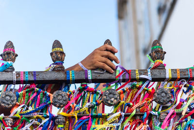 Severed hand of a person holding souvenir ribbons