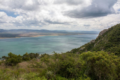 Scenic view of river amidst mountains against cloudy sky