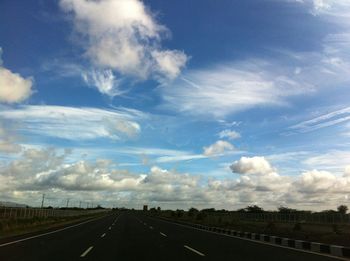 Empty road against cloudy sky