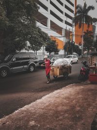 Rear view of man walking on street in city