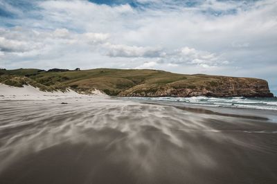 Scenic view of beach and mountains against sky