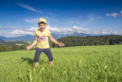 Full length of smiling girl on field