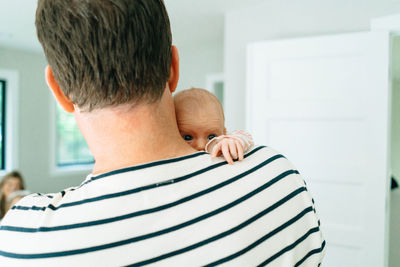 Cropped portrait of a dad holding his baby over his shoulder