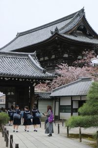 School girls walking on footpath at buddhist temple