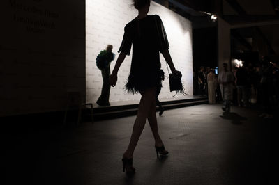 Rear view of silhouette woman walking on floor