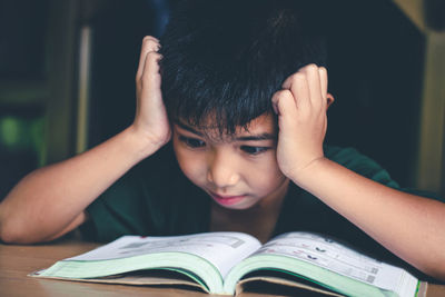 Portrait of boy on book