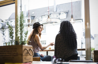 Two friends sitting in cafe, talking