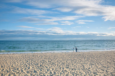 People on beach against sky