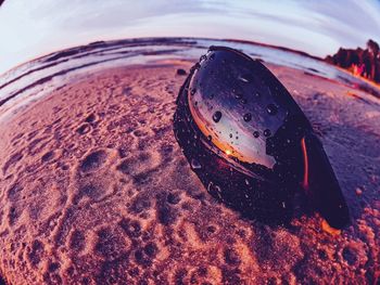 High angle view of wet glass on sand