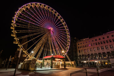 Low angle view of illuminated ferris wheel at night
