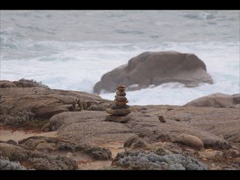 Stack of sculpture on rock against sky