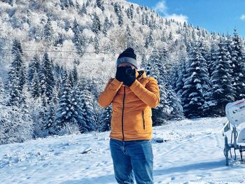 Man photographing on snow covered land