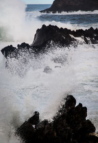 Scenic view of sea waves splashing on rocks